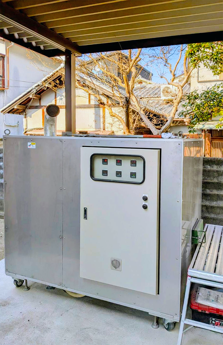 屋根のある屋外に設置されたハリーポットDXの実機。操作盤、扉、脚部まで写る写真